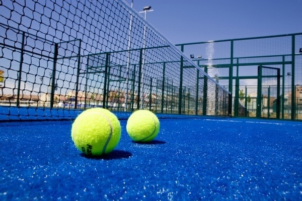 Cancha de pádel con pelotas, imagen del proyecto de app de reservas deportivas.